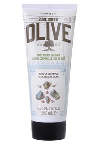 Tube blanc avec un capuchon violet clair. L'étiquette avant présente "OLIVE" en gras gris, indiquant "CRÈME CORPORELLE SEL DE MER" en vert, accompagnée d'illustrations de coquillages.