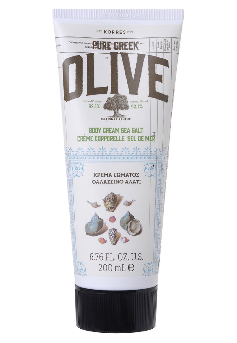 Tube blanc avec un capuchon violet clair. L'étiquette avant présente "OLIVE" en gras gris, indiquant "CRÈME CORPORELLE SEL DE MER" en vert, accompagnée d'illustrations de coquillages.