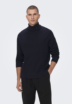 Jūras spēku melns turtlenecks džemperis ar ribotu tekstūru, ar garām piedurknēm un brīvu piegriezumu. Kombinēts ar melniem biksēm, izceļoties ar elegantu dizainu.