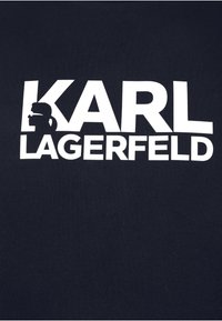 Marineblaue Baumwoll-T-Shirt mit einem großen weißen Logo, das "KARL LAGERFELD" zeigt, begleitet von einer Silhouette einer Figur im Profil.