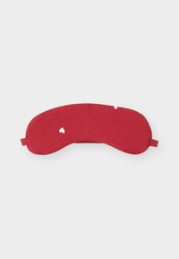 Masque de sommeil en tissu rouge avec de petits motifs de cœurs blancs et une sangle élastique sur un fond clair uni.