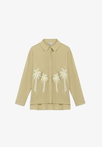 Camisa de botonadura en color beige claro con una tela texturada, con bordado de palmeras blancas en la parte delantera y un cuello clásico.