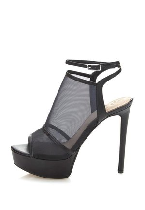 Sorte høje hæle sandaler med mesh-paneler, åben tå, og en ankelrem med spænde. Teksturert platform for ekstra højde.