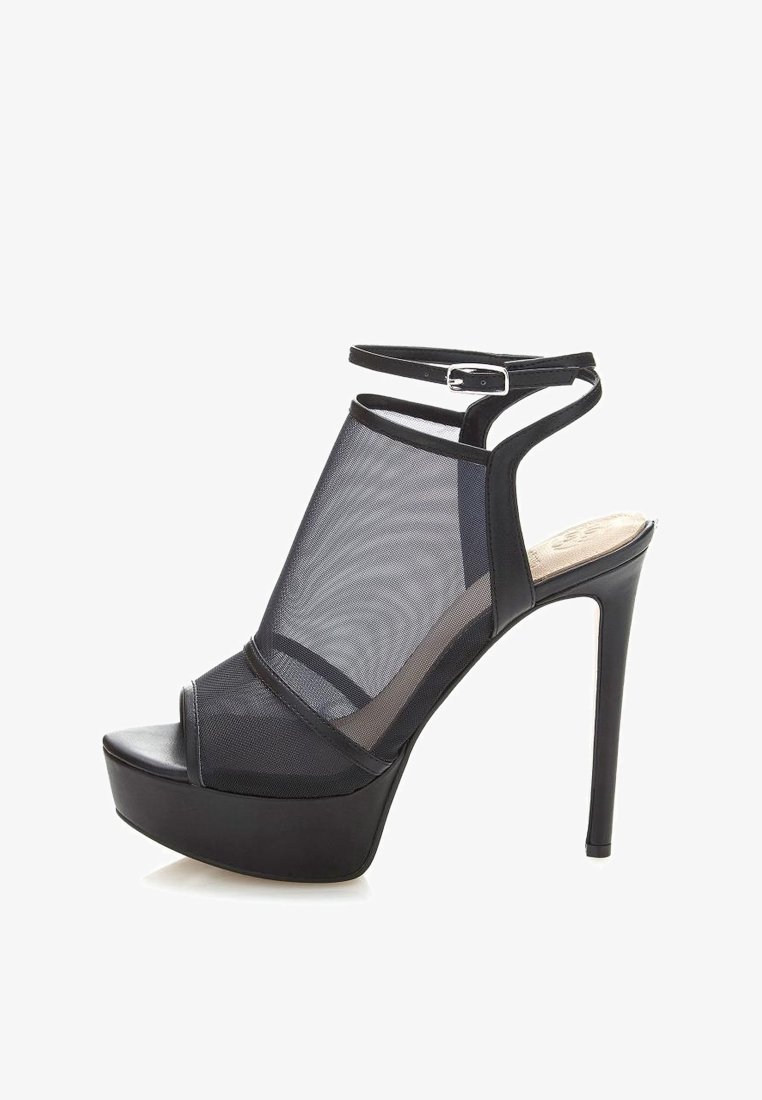 Sandale noire à talons hauts avec des panneaux en maille, un bout ouvert et une bride de cheville avec une boucle. Plateforme texturée pour une hauteur supplémentaire.