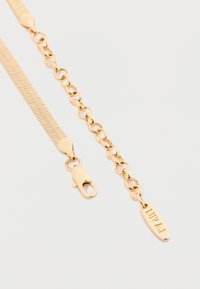 Guldtonet metal kædearmbånd med en glat flad design og et lille mærkat graveret med "LUV AJ." Inkluderer en krabbe-lås til lukning.