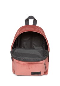 Zaino piccolo di colore rosa polveroso con interno nero e tasca frontale con zip, parzialmente aperto, che mostra il vano principale vuoto e la maniglia in tessuto.