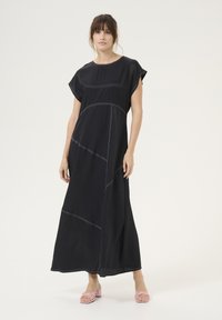 Musternite musta maksikleit lühikeste varrukatega, millel on kontrastne õmblus ja mugav lõige. Sile kangas, nurga all õmblusdetailid kogu ulatuses.