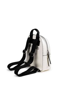 Mochila sintética blanca con correas ajustables negras, bolsillo frontal con cremallera y acabado liso y texturizado. Presenta detalles de hardware en plata.