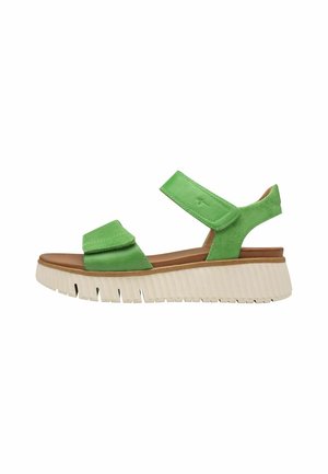 Groene leren sandalen met dubbele verstelbare banden, een leren voetbed in tan kleur en een dikke witte rubberen zool met verticale ribbels.