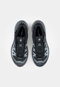 Paire de chaussures de running Salomon noires et grises avec lacets à ouverture rapide, vues de dessus sur fond blanc.