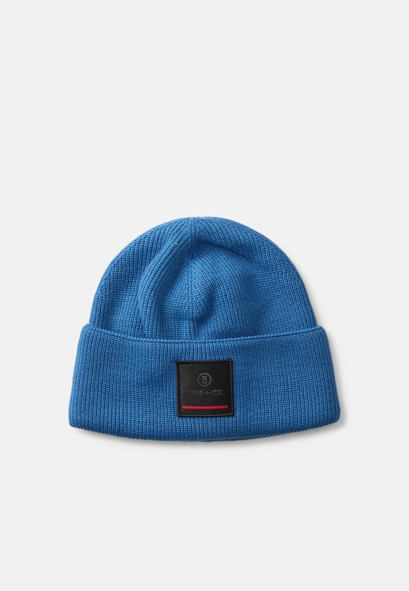 Modrá pletená čiapka s prehnutým lemom. Obsahuje čiernu nášivku s červenými akcentmi. Mäkka textúra, zaoblený vrchol a priliehavý strih.