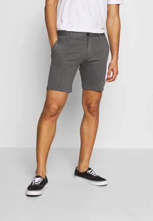 Pantaloni corti grigi in misto cotone, con tasche laterali, frontale piatto e vestibilità rilassata. Abbinati a sneakers nere.
