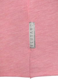 Pinke Baumwoll-T-Shirt mit einem silbernen Logo-Etikett an der Seitennaht. Weicher Stoff mit einem dezenten Strukturmuster und abgerundetem Saumdesign.