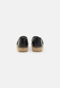 Zwarte lederen espadrilles met een geweven jute zool. Beschikt over een ronde achterkant en gestikte details langs de zoolrand.