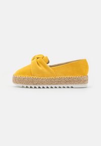 Espadrillas in suede giallo con dettaglio anteriore annodato, suola intermedia avvolta in juta e suola esterna in gomma bianca con motivo seghettato.