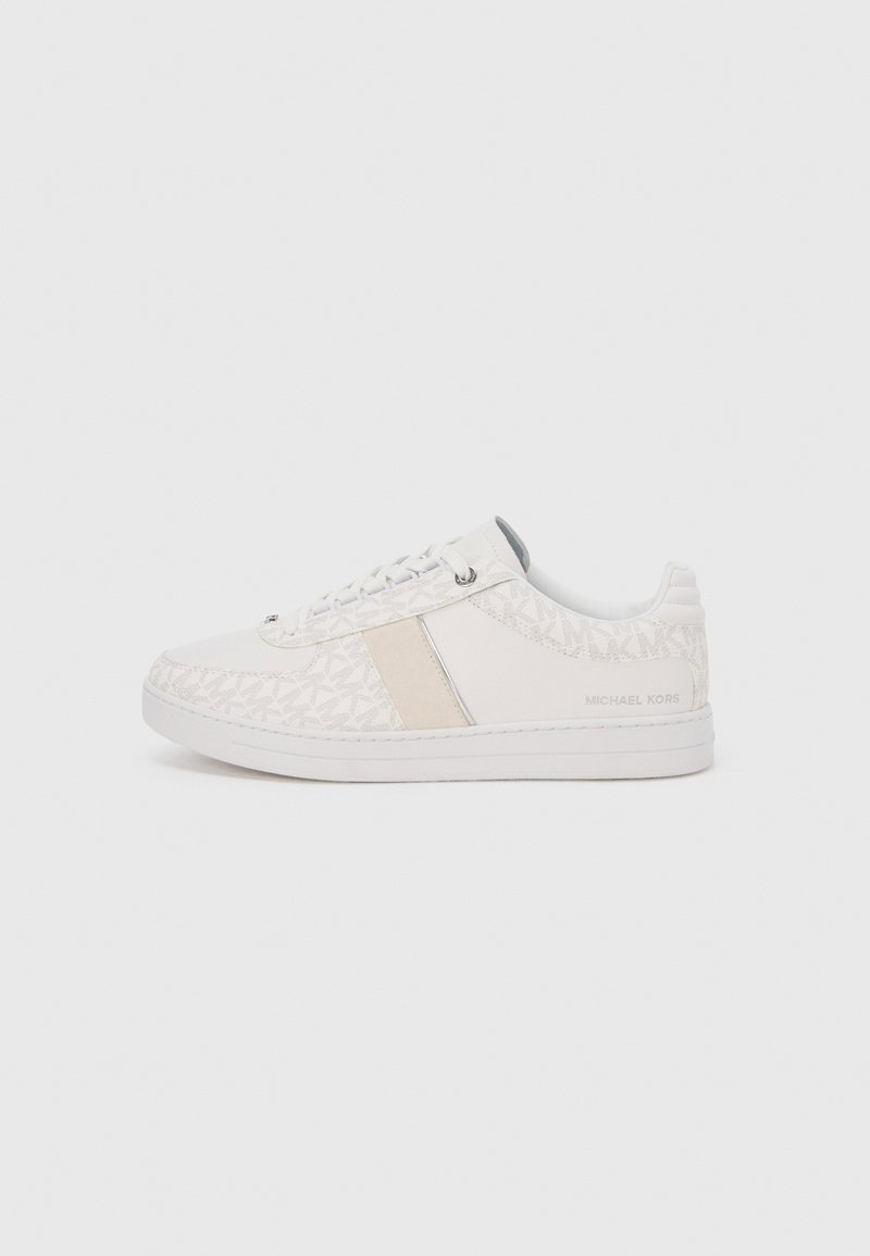 White sneakers featuring a textured fabric upper with a geometric pattern, a beige accent strip, and a rubber sole. Text reads "MICHAEL KORS."
