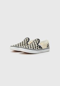 Mustvalged must-valge ruudulised slip-on kingad, millel on kanva ülemine osa, elastsed külgmised aktsendid ja valge kummist tallaplaat. Kerge ja lõdva disain.
