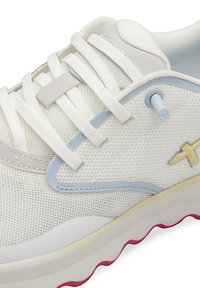 Sneaker bianco in rete con dettagli grigi, occhielli blu e una suola testurizzata con dettagli rosa. I lacci sono lisci e piatti.