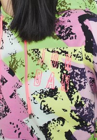 Felpa con cappuccio in colori pastello di rosa, verde e viola con un motivo camouflage. Presenta il logo "JORDAN" ricamato in rosa.