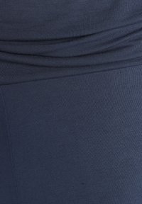 Marine stretchstof met een gladde textuur, voorzien van geplooide details bij de taille en een getailleerd ontwerp voor comfort en flexibiliteit.