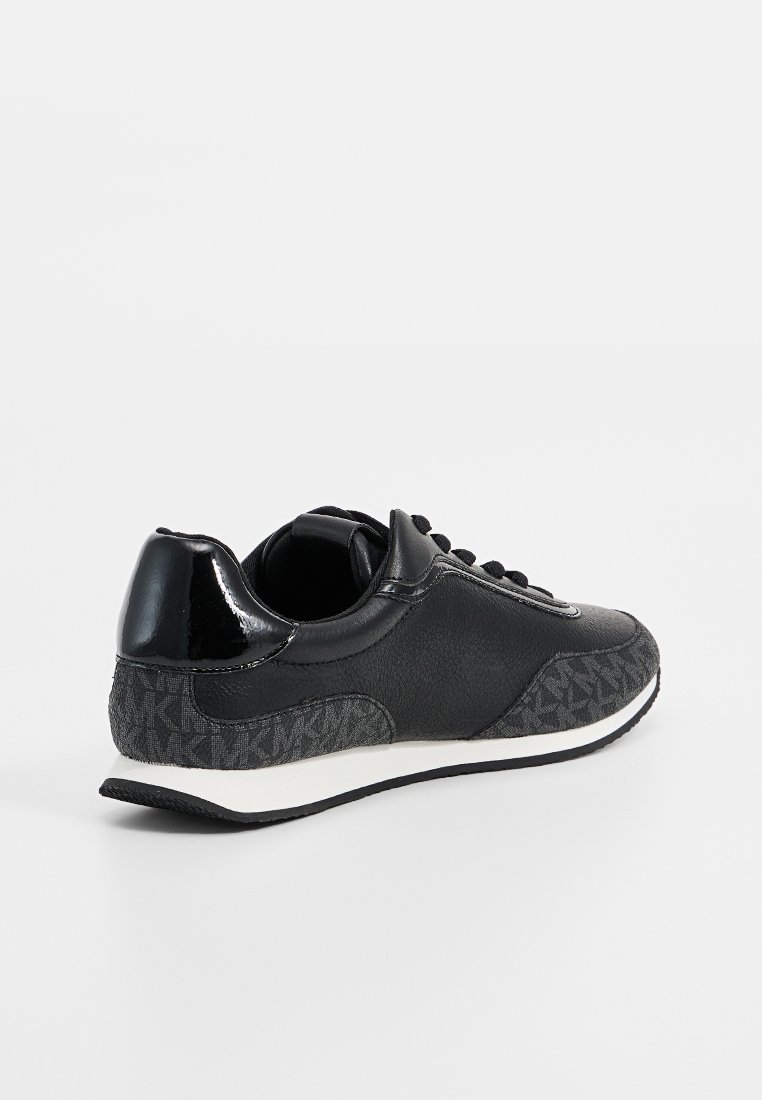 Zwarte laag uitgesneden sneaker met gestructureerde donkergrijze stoffen panelen, glanzende hiel, zwarte veters en witte zool met zwarte loopzool.