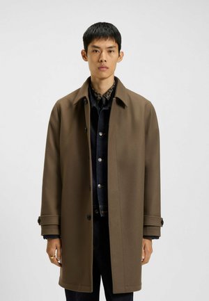 Bruine wollen mix overcoat met een kraag, knopen aan de voorkant en twee zijzakken. Draag het over een donkerdenimshirt.