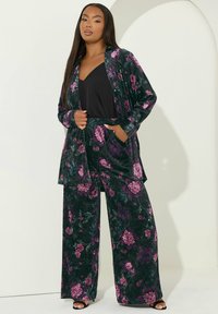 Sammetspajamaset i mörkgrön med rosa och lila blommor. Utrustat med vida byxor och en lång kimono med öppna kanter.