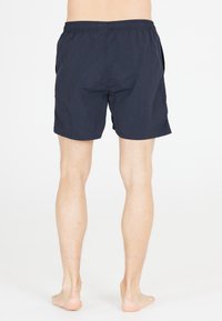 Marinblå badshorts med elastisk midja, sidofickor, tillverkade av lätt och strukturerad tyg, med en avslappnad passform.