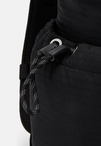 Zaino in tessuto nero con materiale testurizzato e un sottile motivo del logo, chiusura a coulisse e accenti in corda a contrasto.