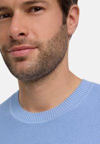 Lichtblauwe gebreide trui met een geribde ronde halslijn, voorzien van een textuurpatroon en een slim fit rondom de hals en schouderpartijen.
