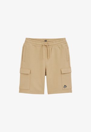 Bēšas kravas šorti ar elastīgu vidukļa joslu, auklu, sānu kabatām un mazu putna logotipu uz labās kājas apakšējās daļas.