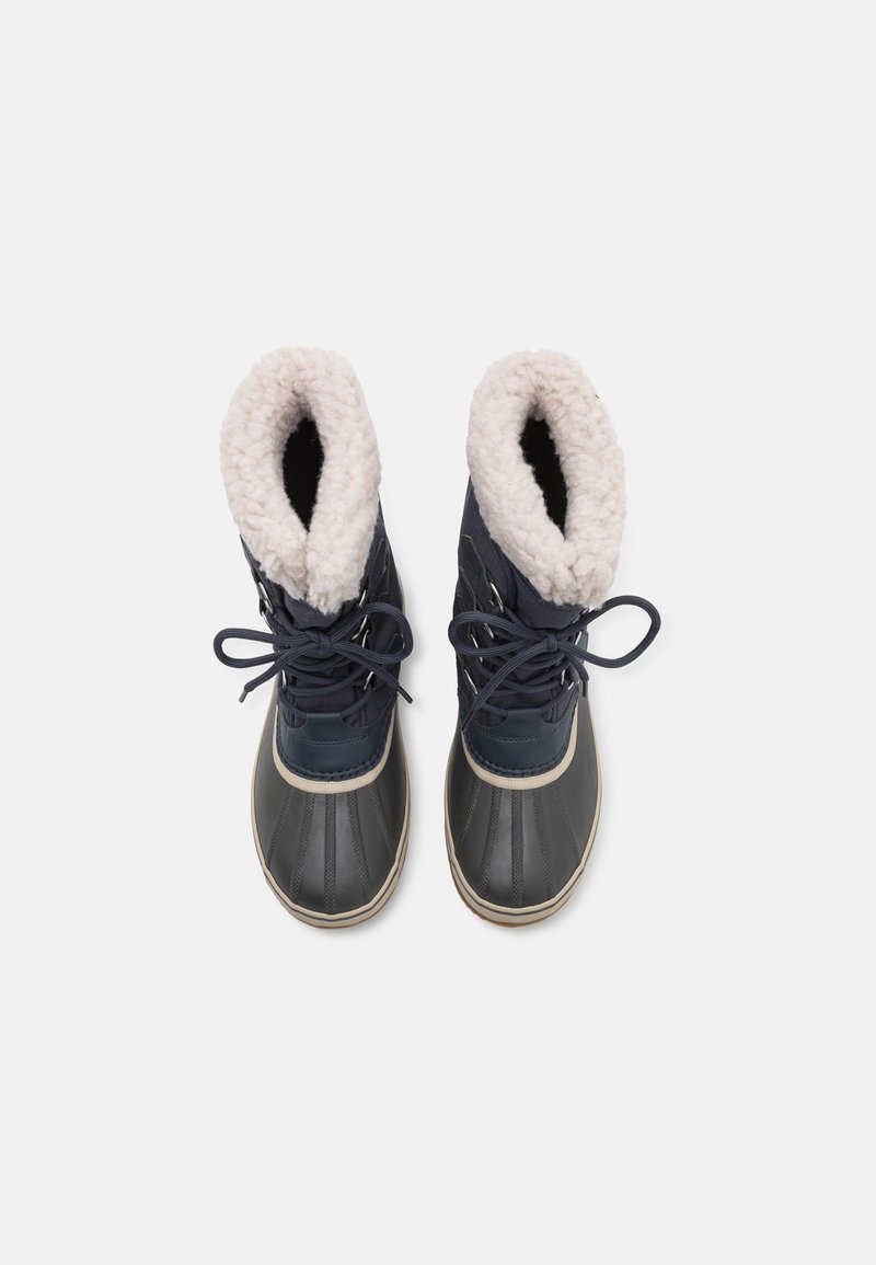 Granatowe wodoodporne buty z futrzanym białym wykończeniem, gumowym podbiciem, okrągłym noskiem i sznurówkami. Teksturowany materiał z gładką podeszwą i kontrastowymi akcentami.