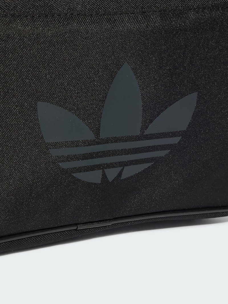 Sac en tissu noir présentant un logo Adidas noir mat avec trois formes de feuilles et trois bandeaux horizontaux. Texture lisse et détails de couture visibles.