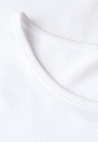Nahaufnahme eines weißen Rundhalsausschnitt-T-Shirts, das die Stoffstruktur und die Nähdetails zeigt.