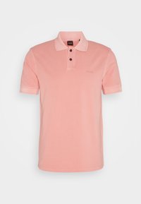 Polo rose à manches courtes avec deux boutons foncés et un col, avec un logo embossé discret sur la poitrine.