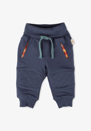 Marineblaue Jogginghosen mit geripptem Bund, dekorativem Kordelzug, gesteppten Knieakzenten und Seitenschlitzen, die karierte Stoffe enthüllen.