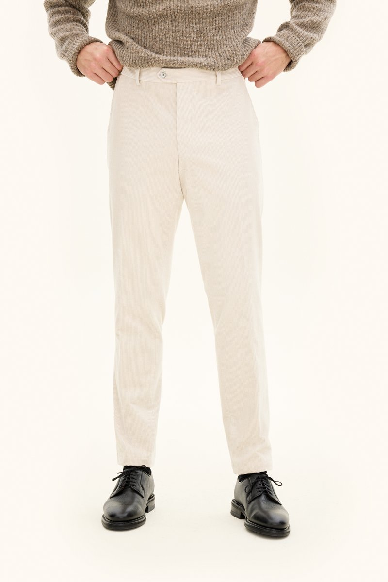 Beige manchesterbyxor med skräddarsydd passform, med knäppning framtill och fickor, kombinerade med svarta finskor.