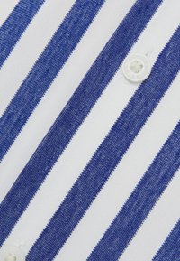 Tela a rayas azul y blanca con franjas horizontales de ancho uniforme, superficie texturizada, con un detalle de botón blanco visible.