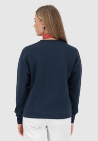 Marineblauwe sweatshirt van zachte stof, met een ronde halslijn en ribgebreide manchetten. Het ontwerp bevat minimale stikdetails.