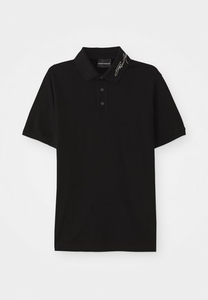 Svart polotröja i mjukt material, med krage, placket med tre knappar, korta ärmar och signerad detalj på kragen.