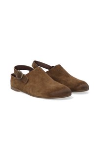 Brune ruskinds slip-on sko med åben hæl, der har en rund tå, en bred rem og en cirkulær metalspænde på siden samt en glat sål.
