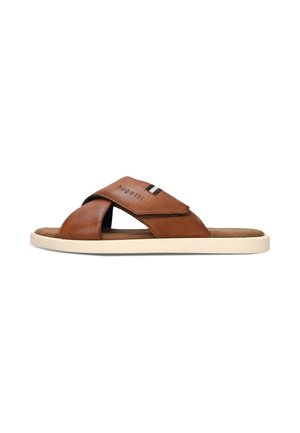 Sandalia de cuero marrón tipo slip-on con tiras cruzadas y suela blanca, con el nombre de la marca "bugatti" en la tira superior.