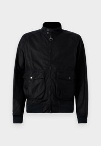 Black bomber jacket made of durable fabric, featuring a front zipper, two large snap-button pockets, and ribbed cuffs and hem.