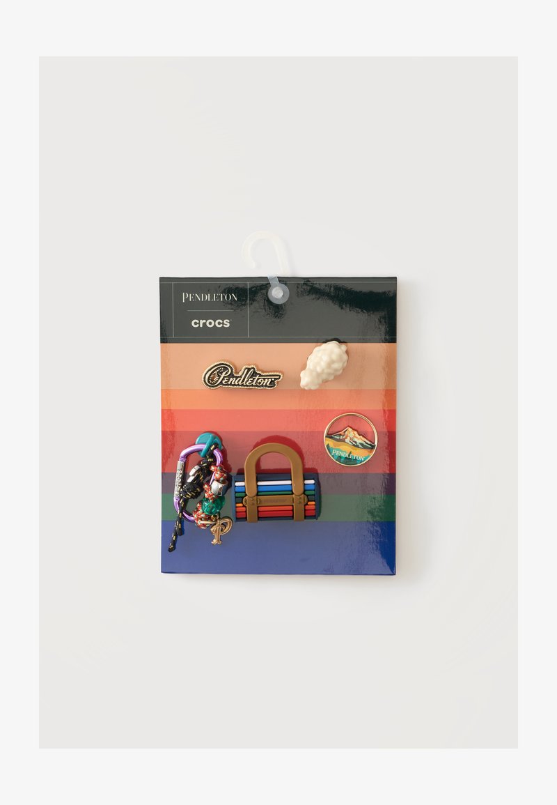 Ensemble de cinq breloques colorées Pendleton Crocs Jibbitz sur une carte rayée, comprenant un sac à main, un patch, un bracelet, un mouton et le logo Pendleton.