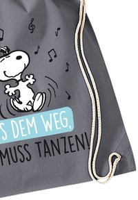 Borsa a tracolla grigia con un cane a cartoni animati che balla, note musicali e testo in blu e nero: "Das Dem Weg, muss tanzen!"