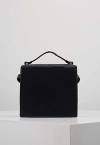 Czarna torebka z ekoskóry o uporządkowanym, prostokątnym kształcie, z górnym uchwytem i minimalistycznym designem. Brak widocznych metalowych elementów lub zdobień.