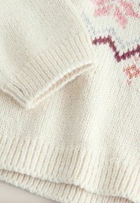 Strikket sweater i creme med ribbede manchetter og kant, prydet med et geometrisk mønster i lyserøde og lilla nuancer. Teksturopstrikket uld.