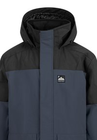 Herrenjacke mit einem schwarzen oberen Bereich und einem marineblauen Körper, aus wasserfestem Material, hohem Kragen und einem Logo-Patch auf der Brust.