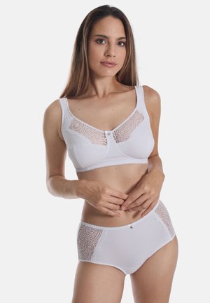 Weißes Lingerie-Set mit einem BH mit Spitzenakzenten und einem runden Knopfdetail, kombiniert mit passenden hochtaillierten Panties mit Spitzen-Seiten.