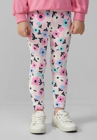 Legginsy wykonane z elastycznego materiału, z pastelowo-różowym tłem, z wielokolorowymi wzorami kwiatowymi i czarnymi łodygami.